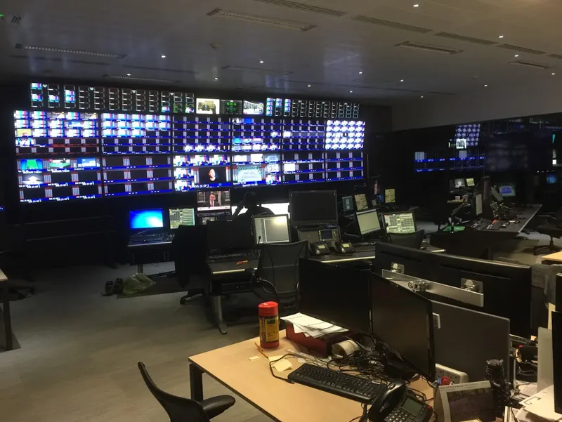 A wide view of IMG's Stockley Park master control room, showing the full monitor wall and the operator and engineering desks in front of it.