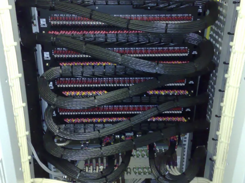Black multicore cable looms looped neatly across rows of audio patch jackfields in Virgin Media's Knowsley headend.