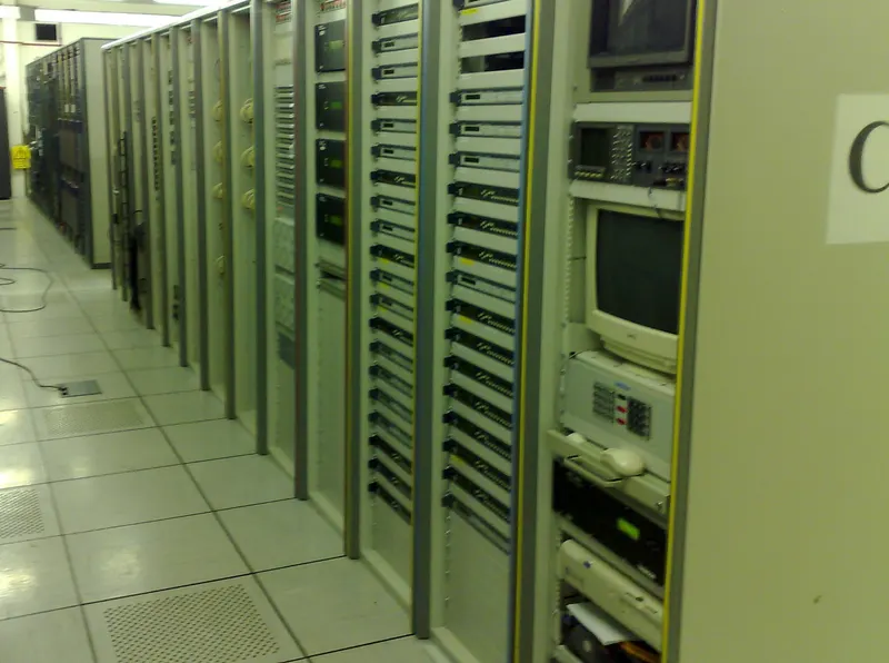 An aisle between rows of headend equipment racks on the raised floor of Virgin Media's Knowsley headend.