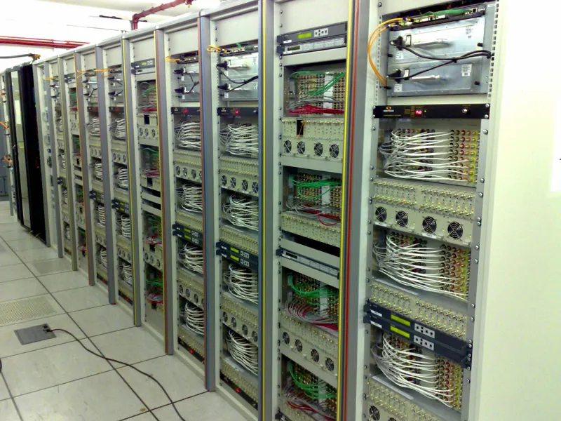 A row of open equipment racks in Virgin Media's Knowsley national headend, filled with headend equipment and neatly looped coax cabling.